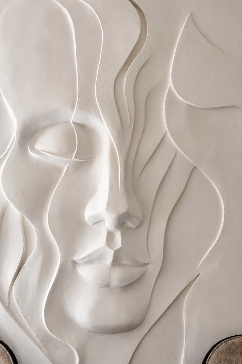 Female face rendered as a sculptural wall relief